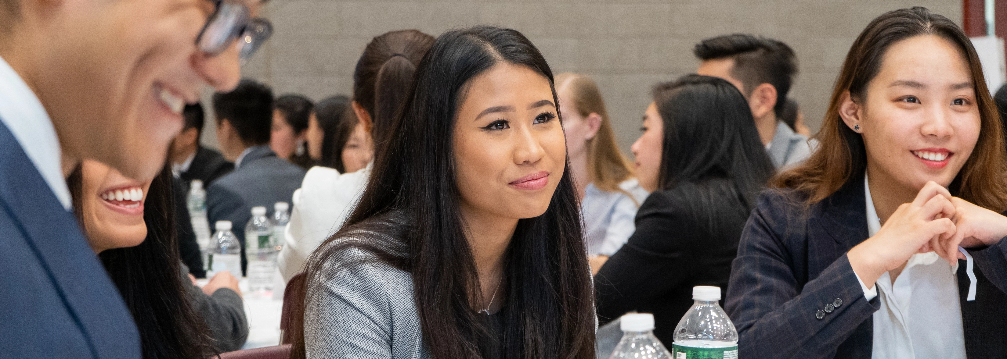 SUNY Stony Brook University College of Business MBA STudents attending an event sitting at a table in conversation
