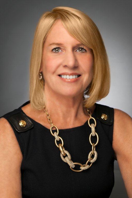 Susan Palmer Blonde female wearing a black suit posing in front of grey background