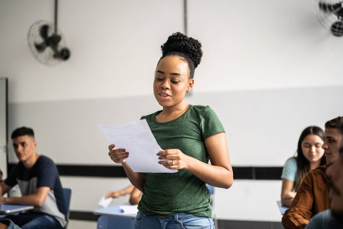 A high school student demonstrates speech sounds in a classroom